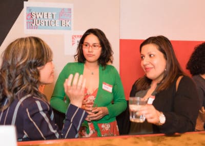 Three women sit at the bar and chat
