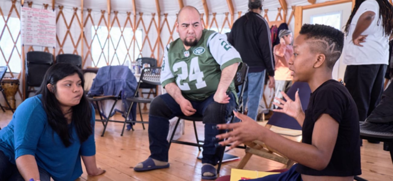 A group of three people talking in a small group in a workshop